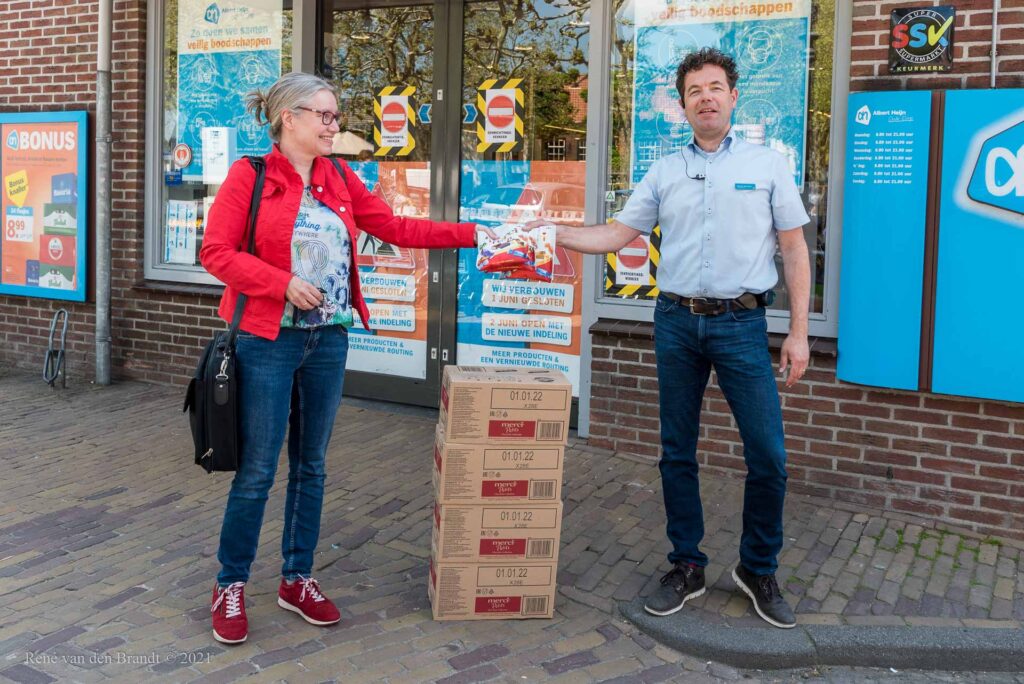 Martijn Steenman van AH Oude Dorp overhandigt zakjes Merci