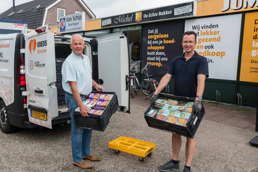 Vrijwilligers van voedselbank en Lionsclub laden de koelbus in